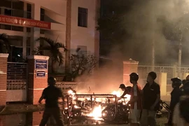 Một số đối tượng quá khích lôi xe máy từ trong Sở Kế hoạch và Đầu tư tỉnh Bình Thuận ra đốt phá. (Ảnh: Nguyễn Thanh/TTXVN)