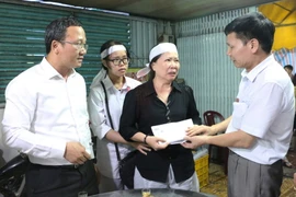 Ông Ngô Văn Quang, Chủ tịch Công đoàn Cục đường thủy nội địa (phải) trao cho gia đình ông Nguyễn Văn Dũng (người đã không may tử nạn trong lúc làm nhiệm vụ) số tiền 50 triệu đồng. (Ảnh: Công Mạo/TTXVN)