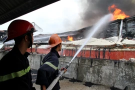 Lực lượng phòng cháy chữa cháy tích cực dập lửa tại khu vực cháy. (Ảnh: Trung Kiên/TTXVN)