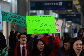 Người dân biểu tình phản đối hành vi cư xử không đúng mực của nhân viên Hãng hàng không United Airlines với khách hàng tại sân bay quốc tế Chicago, bang Illinois. (Nguồn: AFP/TTXVN)