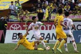 Công Phượng (áo trắng) trong trận gặp Sông Lam Nghệ An. (Ảnh: Thanh Tùng/TTXVN)