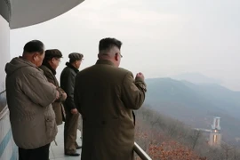 Nhà lãnh đạo Triều Tiên Kim Jong-un (phải) theo dõi việc thử động cơ tên lửa tại một địa điểm bí mật. (Nguồn: EPA/TTXVN)