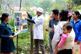 Nhân viên y tế tuyên truyền phòng chống sốt rét cho đồng bào dân tộc xã biên giới Dân Hóa, huyện miền núi Tuyên Hóa. (Ảnh: Dương Ngọc/TTXVN)