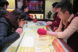 Khách hàng đang giao dịch vàng miếng. (Ảnh: Đức Duy/Vietnam+)