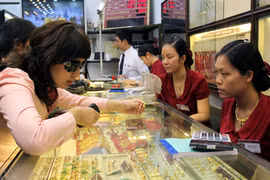 Khách hàng đang giao dịch vàng miếng. (Ảnh: TTXVN)