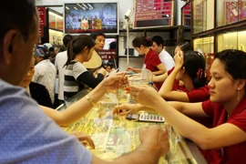 Khách hàng đang giao dịch vàng miếng. (Ảnh: TTXVN)