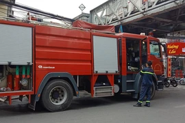 Lực lượng phòng cháy chữa cháy có mặt tại hiện trường vụ cháy tại phố cổ. (Ảnh: Hùng Võ/Vietnam+) 