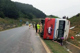 Hiện trường vụ lật xe chở khách du lịch trên Quốc lộ 6, tỉnh Sơn La. (Ảnh: TTXVN phát)