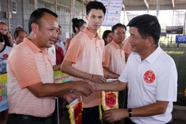 Trưởng đại diện Cơ quan Công an Việt Nam tại Lào, Thiếu tướng Hoàng Quang Hướng trao cờ lưu niệm cho Đại diện đội Ủy ban Hợp tác Lào-Việt. (Ảnh: Phạm Kiên/TTXVN)