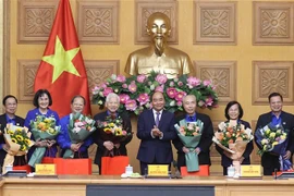 Thủ tướng Nguyễn Xuân Phúc tặng quà cho các đại biểu tại buổi gặp mặt. (Ảnh: Thống Nhất/TTXVN)