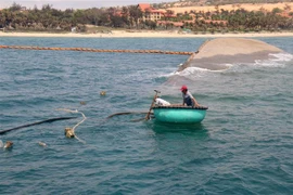 Lực lượng chức năng hút dầu từ tàu Bạch Đằng đang bị chìm. (Ảnh: Nguyễn Thanh/TTXVN)