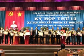 Tặng Bằng khen cho các cá nhân có nhiều đóng góp trong hoạt động của Hội đồng nhân dân tỉnh Bình Định khóa XII. (Ảnh: Phạm Kha/TTXVN)