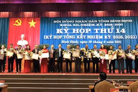 Tặng Bằng khen cho các cá nhân có nhiều đóng góp trong hoạt động của Hội đồng nhân dân tỉnh Bình Định khóa XII. (Ảnh: Phạm Kha/TTXVN)