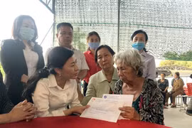 Bà Phan Kiều Thanh Hương, Phó Chủ tịch Ủy ban Mặt trận Tổ quốc Việt Nam Thành phố Hồ Chí Minh (trái), thăm hỏi, động viên thân nhân gia đình nạn nhân thiệt mạng trong vụ cháy. (Ảnh: TTXVN phát)