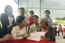 Bà Phan Kiều Thanh Hương, Phó Chủ tịch Ủy ban Mặt trận Tổ quốc Việt Nam Thành phố Hồ Chí Minh (trái), thăm hỏi, động viên thân nhân gia đình nạn nhân thiệt mạng trong vụ cháy. (Ảnh: TTXVN phát)