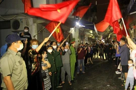 Người dân lô 112 khu tập thể Công nhân Dư Hàng vui mừng trước giờ gỡ bỏ lệnh phong tỏa. (Ảnh: An Đăng/TTXVN)