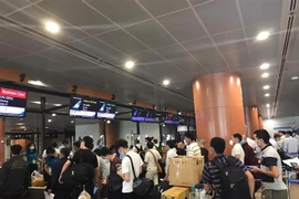 Các công dân Việt Nam làm thủ tục tại sân bay. (Ảnh: TTXVN phát)