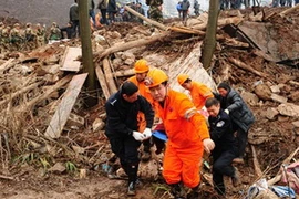 Nhân viên cứu hộ làm nhiệm vụ tại hiện trường vụ lở đất. (Ảnh: Xinhua)