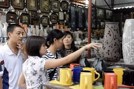 Khách tham quan mua sắm sản phẩm gốm Bát Tràng. (Ảnh: Trần Thanh Giang/TTXVN)