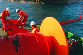 Các cơ quan chức năng dùng phao vây ngăn chặn sự cố tràn dầu ở cảng Dung Quất. (Nguồn: tinngan.vn)