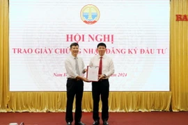 Trao Giấy chứng nhận đăng ký đầu tư dự án cho nhà đầu tư. (Ảnh: Thái Thuần/TTXVN)