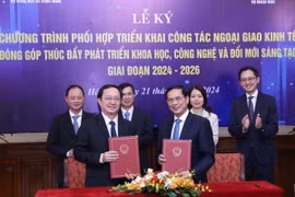 Bộ trưởng Bộ Ngoại giao Bùi Thanh Sơn và Bộ trưởng Bộ Khoa học và Công nghệ Huỳnh Thành Đạt trao văn kiện ký kết. (Ảnh: Lâm Khánh/TTXVN)