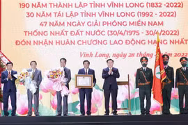 Chủ tịch Quốc hội Vương Đình Huệ gắn Huân chương Lao động hạng Nhất của Chủ tịch nước cho Đảng bộ, chính quyền và nhân dân tỉnh Vĩnh Long. (Ảnh: Doãn Tấn/TTXVN)