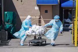 Nhân viên y tế chuyển thi thể bệnh nhân COVID-19 tại New York (Mỹ). (Ảnh: AFP/TTXVN)
