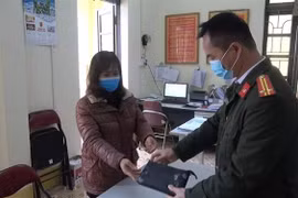 Chị Hoàng Hồng Lĩnh trao số tiền nhặt được cho Công an phường Tân Giang (Cao Bằng), đề nghị Công an xác minh, trao trả số tiền cho người mất. (Ảnh: TTXVN)