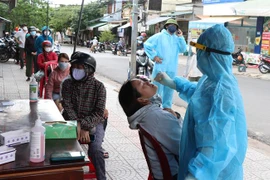 Lấy mẫu xét nghiệm COVID-19 cho người dân ở phường 5, thành phố Đông Hà (Quảng Trị). (Ảnh: Nguyên Lý/TTXVN)
