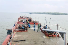 Cán bộ, chiến sỹ bộ đội Biên phòng Thành phố Hồ Chí Minh kiểm tra tang vật cát vận chuyển trái phép trên phương tiện bị bắt giữ. (Ảnh: TTXVN)