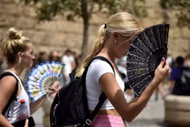 Người dân dưới trời nắng nóng tại Seville (Tây Ban Nha) ngày 13/6/2022. (Ảnh: AFP/TTXVN)