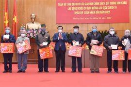 Bí thư Thành ủy Hà Nội Đinh Tiến Dũng trao quà cho các gia đình chính sách, đối tượng khó khăn, lao động nghèo, tại quận Hoàng Mai. (Ảnh: TTXVN)