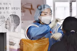 Nhân viên y tế lấy mẫu xét nghiệm COVID-19 cho người dân tại Seoul (Hàn Quốc), ngày 26/1/2022. (Ảnh: Kyodo/TTXVN)