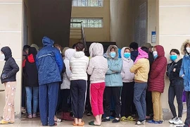 Công nhân chen nhau làm thủ tục xét nghiệm nhanh tại trạm y tế phường Bình Minh, thị xã Nghi Sơn (Thanh Hóa). (Ảnh: Trịnh Duy Hưng/TTXVN)