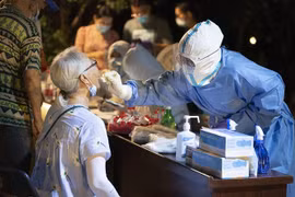 Nhân viên y tế lấy mẫu xét nghiệm COVID-19 cho người dân tại Vũ Hán, tỉnh Hồ Bắc (Trung Quốc), hồi tháng 8/2021. (Ảnh: THX/TTXVN)