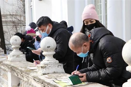 Kiều bào tới làm thủ tục xin cấp thẻ thông hành tại Đại sứ quán Việt Nam ở Romania. (Ảnh: Mạnh Hùng/TTXVN)