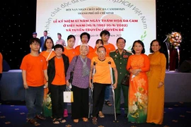 Thiếu tướng Trần Ngọc Thổ, Chủ tịch Hội nạn nhân chất độc da cam-dioxin Thành phố Hồ Chí Minh chụp ảnh lưu niệm cùng các hội viên và nạn nhân chất độc da cam. (Ảnh: Thanh Vũ/TTXVN)