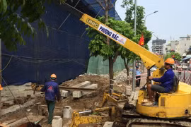 Công ty cổ phần Phương Bắc đang thực hiện đào đất để đổ bê tông trụ móng, đưa cẩu tháp vào phá dỡ 8B Lê Trực. (Ảnh Mạnh Khánh/TTXVN)