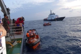 Các xuồng của Việt Nam cập mạn tàu Indonesia để đón ngư dân. (Ảnh: Đỗ Quyên/TTXVN)