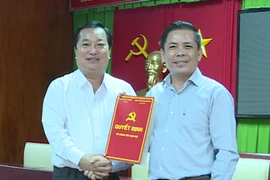 Bí thư Tỉnh ủy Sóc Trăng, ông Nguyễn Văn Thể trao quyết định của Ban Bí thư cho ông Trần Văn Chuyện (áo trắng, bên trái). (Ảnh: Trung Hiếu/TTXVN)