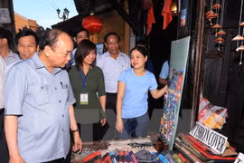 Thủ tướng Nguyễn Xuân Phúc thăm các gian hàng tại khu du lịch phố cổ Hội An. (Ảnh: Thống Nhất/TTXVN)