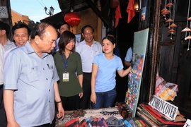 Thủ tướng Nguyễn Xuân Phúc thăm các gian hàng tại khu du lịch phố cổ Hội An. (Ảnh: Thống Nhất/TTXVN)