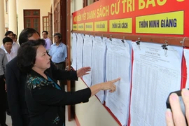 Chủ tịch Quốc hội Nguyễn Thị Kim Ngân kiểm tra nơi niêm yết danh sách cử tri tại xã Cổ Thành, thị xã Chí Linh, Hải Dương. (Ảnh: Trọng Đức/TTXVN)