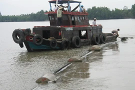 Thi công công trình lắp đặt đường ống ngầm vượt sông Tiền đưa nước sinh hoạt về huyện cù lao Tân Phú Đông. (Nguồn: TTXVN)