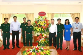 Ông Nguyễn Đức Lợi, Ủy viên Trung ương Đảng, Tổng Giám đốc TTXVN đón nhận lẵng hoa chúc mừng Tổng cục II, Bộ Quốc phòng. (Ảnh: Doãn Tấn/TTXVN) 