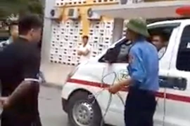 Bảo vệ công ty AZ dùng xích chặn xe cứu thương ở bệnh viện Nhi Trung ương. Ảnh chụp ra từ clip.