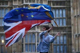 Một người biểu tình vẫy cờ Anh và EU bên ngoài tòa nhà Quốc hội Anh. (Nguồn: AFP/TTXVN)