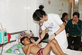 Y, bác sỹ thăm khám cho bệnh nhân sốt xuất huyết tại Bệnh viện Đa khoa tỉnh Đắk Lắk. (Ảnh: Dương Giang/TTXVN)