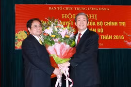 Ông Đinh Thế Huynh, Ủy viên Bộ Chính trị, Thường trực Ban Bí thư trao Quyết định và tặng hoa cho ông Phạm Minh Chính. (Ảnh: Doãn Tấn/TTXVN)